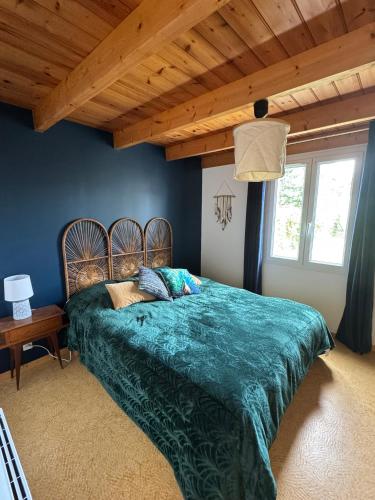 a bedroom with a green bed with a wooden ceiling at La Fleur des Marais - Maison tout confort au calme, grand jardin & balançoire in Le Château-dʼOléron