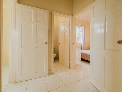 a bathroom with a door leading to a bedroom at Lunar Apartments in Saint Michael