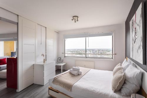 a white bedroom with a bed and a window at L'Horizon by Cocoonr in Rennes