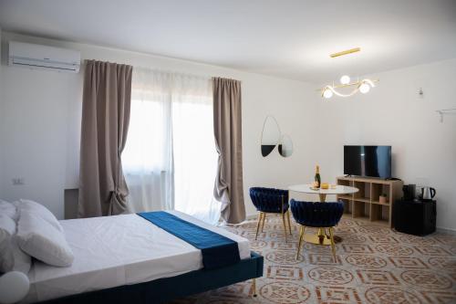 a bedroom with a bed and a table with chairs at Firmamento Royal House in Rocca Priora