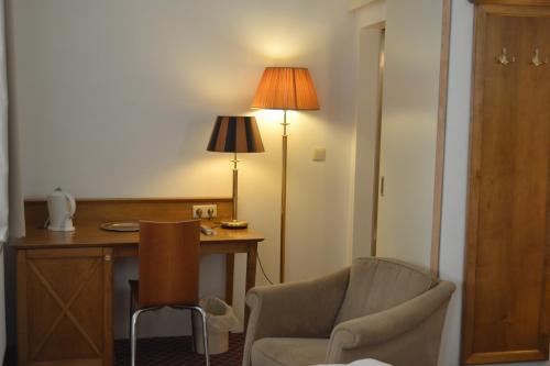 a room with a desk and a chair and a lamp at Hotel The Lord in Ghent