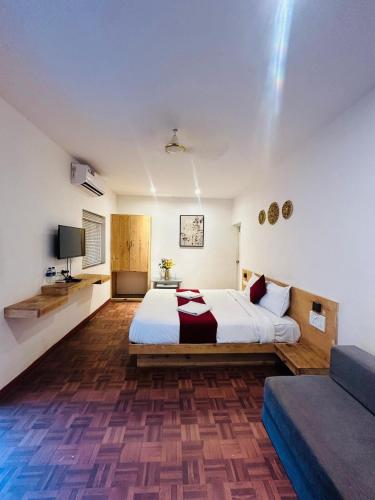 a large bedroom with a bed and a couch at Hotel Inn morjim in Morjim