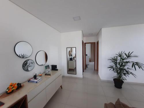 a bathroom with white walls and white floors and mirrors at Casa com piscina e hidromassagem in Ilhéus