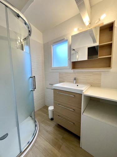 a bathroom with a sink and a shower at Palombes 5 in Lacanau