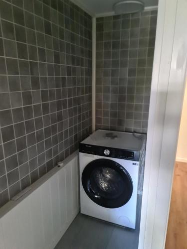 a washer and dryer in a corner of a bathroom at Søvikhus in Haram