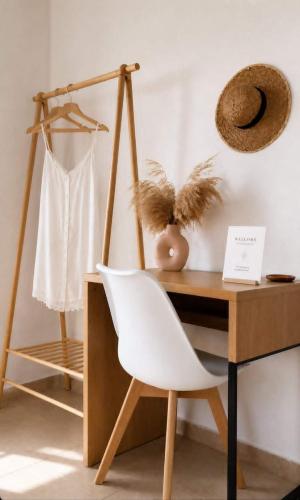 a desk with a white chair next to a wooden table at Gaia Serifos Apartments in Rámos