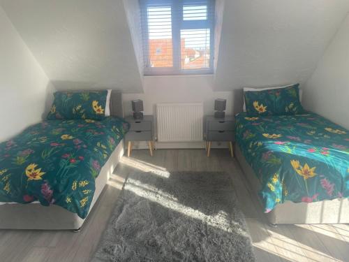 a bedroom with two beds and a window at Wilton Manor 79 Wilton road in Feltwell