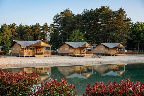 a row of lodges with their reflections in the water at Arden Parks Tulderheyde in Poppel