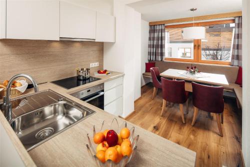 a kitchen with a sink and a bowl of fruit on a counter at Appartements Dr. Schalber in Serfaus