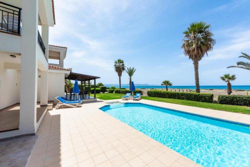 a villa with a swimming pool and the ocean at Seafront Villa Ocean Pearl - Private Beach Area & Pool in Polis Chrysochous