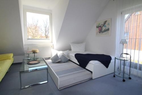 a white room with a bed and a table at Ferienhaus Lütt Matten in Wustrow