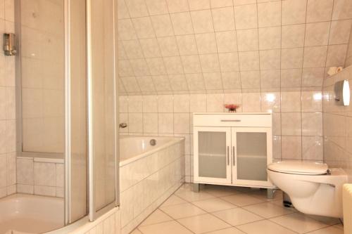 a bathroom with a toilet and a tub and a sink at Ferienhaus Lütt Matten in Wustrow