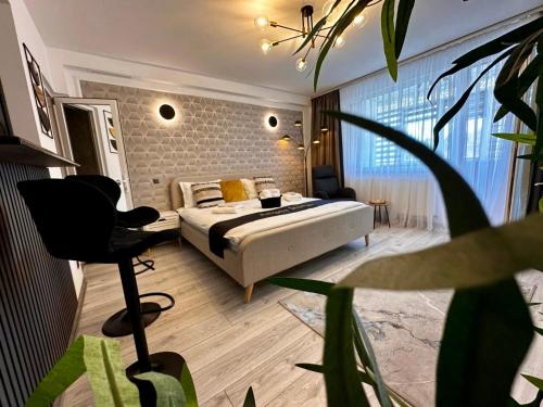 a bedroom with a bed and a chair in it at Angely Studio-balcon & parcare gratuită ,Self Check-in in Onești