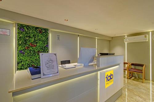 a counter with a sign on it with a green wall at FabHotel Casa Grand Ecil in Hyderabad