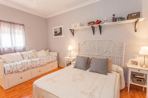 een slaapkamer met 2 bedden en 2 lampen aan de muur bij Apartamento Centro Jerez Carbón in Jerez de la Frontera