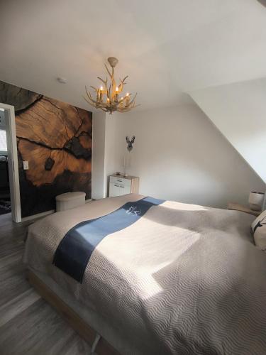 a bedroom with a large bed and a chandelier at Ferienwohnung Kampić Hirsch & Heimat in Rottweil