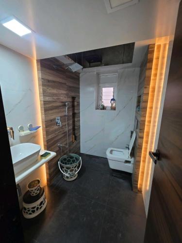 a bathroom with a white toilet and a sink at Tova in Mettuppālaiyam