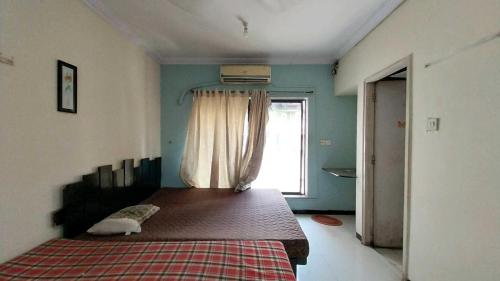 a bedroom with a large bed with a window at Tova in Mettuppālaiyam