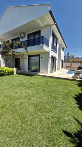 a house with a lawn in front of it at Villa Kalinda Your Private Sheltered Luxury Villa with Pool Minutes Away from Dalaman Airport in Dalaman