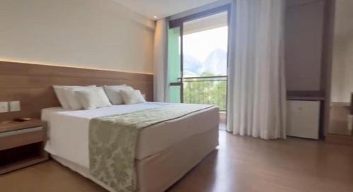 a bedroom with a large bed and a large window at VISTA AZUL Prime in Domingos Martins