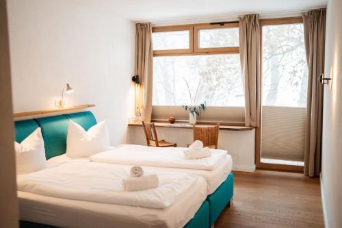 two beds in a room with a window at Hotel Lethehof in Wardenburg