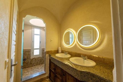 a bathroom with two sinks and two mirrors at Villa Aurea Marrakech in Gzoula