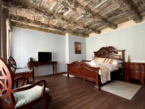 a bedroom with a bed with a coffered ceiling and a chair at Prague Golden Age in Prague