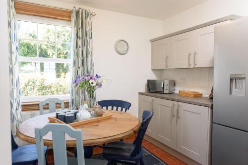 a kitchen and dining room with a table and chairs at Shell Cottage in Whithorn