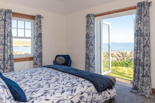 a bedroom with a bed and a large window at Shell Cottage in Whithorn