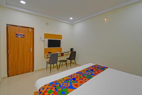 a bedroom with a bed and a desk with a computer at FabHotel GG Stays in Lingampalli