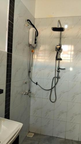 a shower in a bathroom with a phone on the wall at Vito Haven suites in Busia