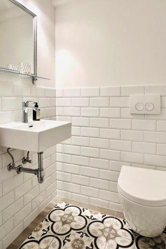 a white bathroom with a sink and a toilet at Das Stader Zuhause in Stade