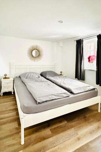 a white bed in a white room with a mirror at Das Stader Zuhause in Stade