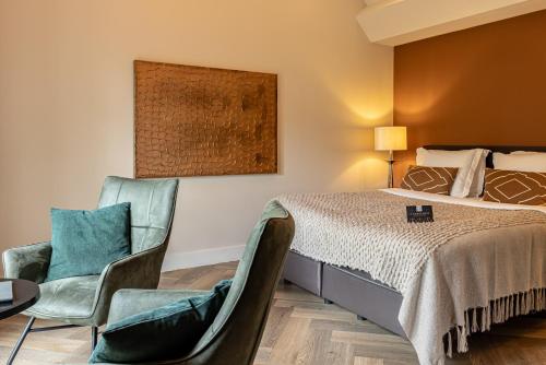 a hotel room with a bed and two chairs at 't Ganzenest Restaurant # klein hotel in Rijswijk