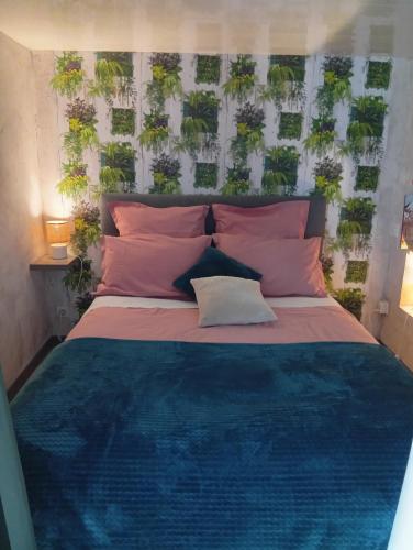 a bedroom with a bed with plants on the wall at Mini gite 1à4 personnes Studio 7 in Gelles