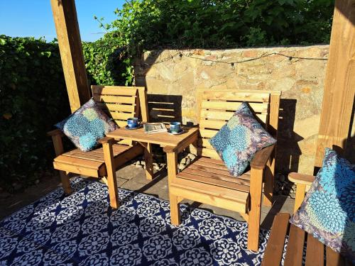 a wooden table and two chairs on a patio at Mulberry Cottage in Whithorn