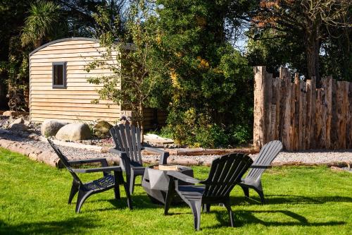 a group of chairs and a table in the grass at Rowan in Whithorn