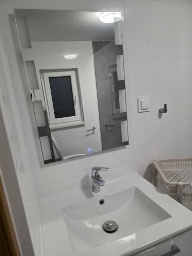a white bathroom with a sink and a mirror at DELFIN - Lawendowy Zakątek in Sianozety