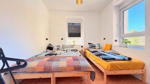 two twin beds in a room with a window at Whirlpool Sauna Pool Bad Ems in Bad Ems