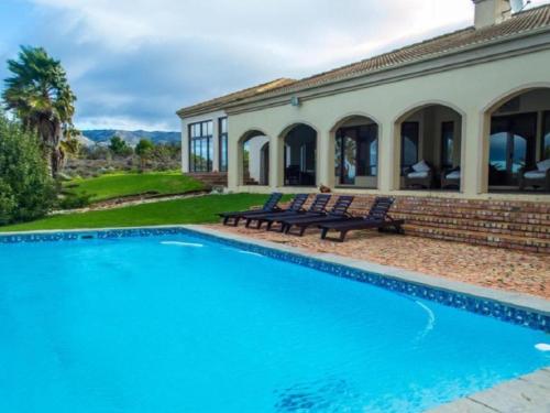 a swimming pool in front of a house at Barton Luxury Villas in Hermanus