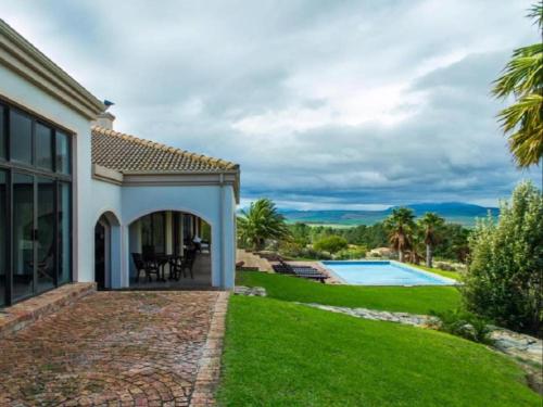 a house with a garden and a swimming pool at Barton Luxury Villas in Hermanus