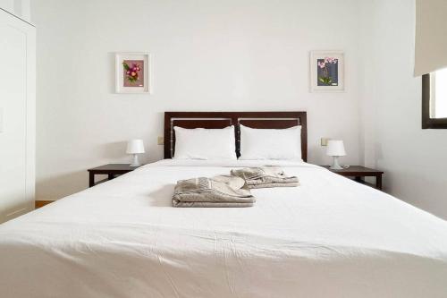 a large white bed with a blanket on it at Lamar Suites in Arinaga