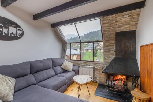 a living room with a couch and a fireplace at Dúplex acogedor en La Molina- 8 Pax in La Molina