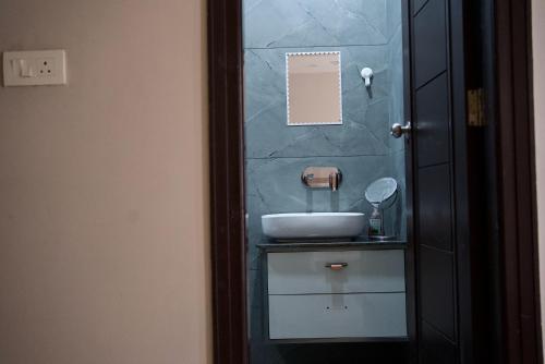 a bathroom with a sink and a mirror at Amur Stay 2 in Sohāna