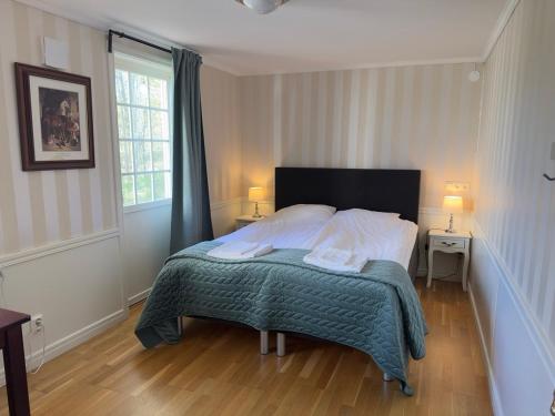 a bedroom with a bed with two lamps and a window at Aspa Herrgård - Handelshuset in Askersund