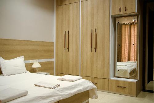 a bedroom with a bed and a cabinet with a mirror at Amur Stay 2 in Sohāna