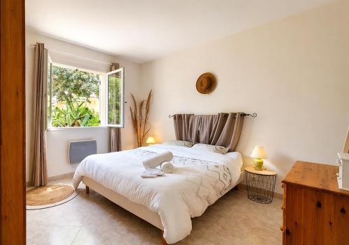 a bedroom with a large white bed and a window at Piscine & Vue Mer, Maison Familiale Corse, accès cascade in Santa-Maria-Poggio