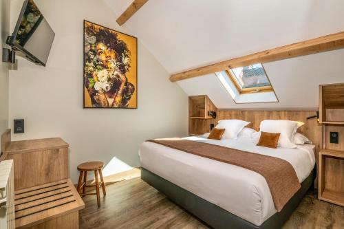 a bedroom with a large bed and a skylight at Hôtel-Restaurant Logis l'Aubrac Laguiole in Laguiole