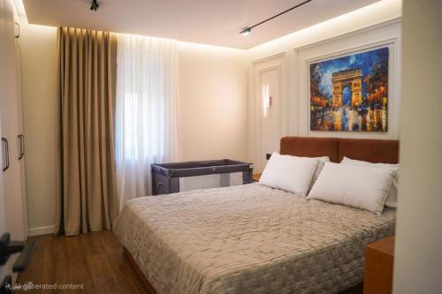 a bedroom with a bed and a painting on the wall at Cuzi House in Librazhd