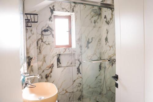 a bathroom with a shower with a toilet and a sink at Cuzi House in Librazhd